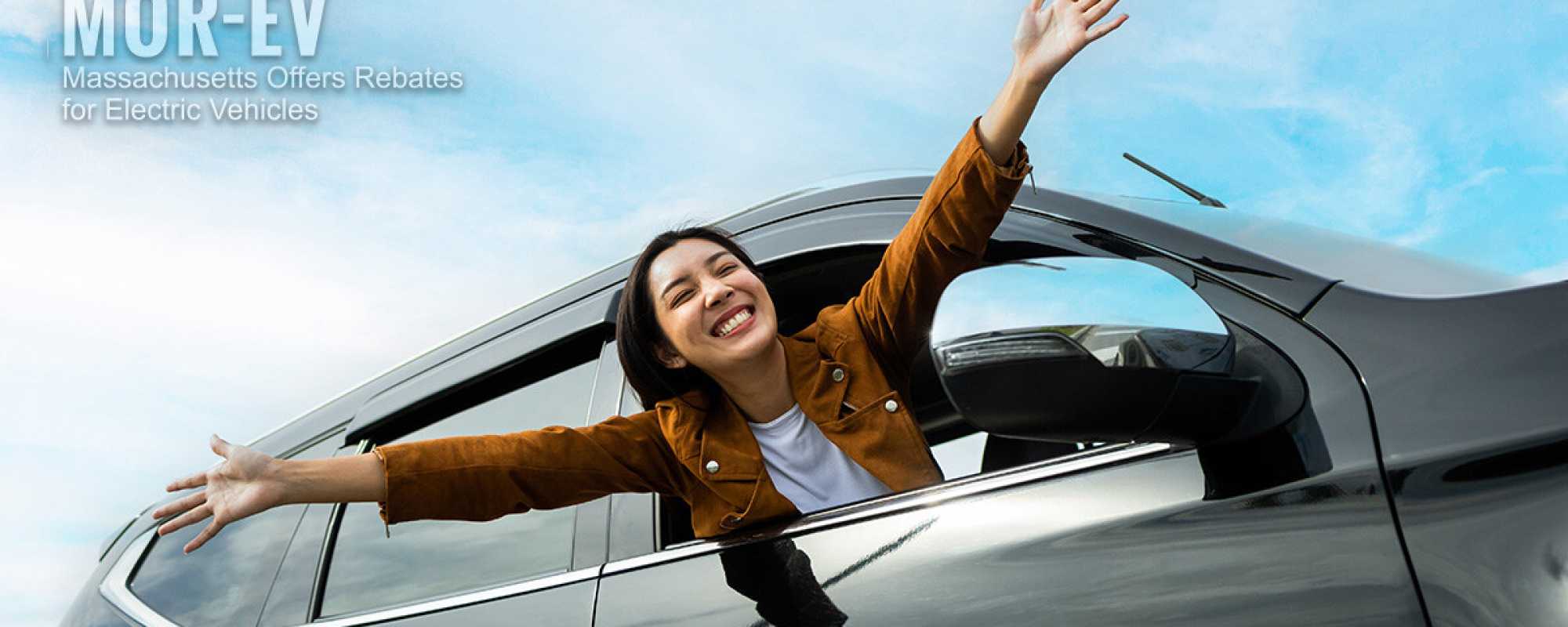 MOR EV Photo. WOman leaning out of the car window with arms spread out