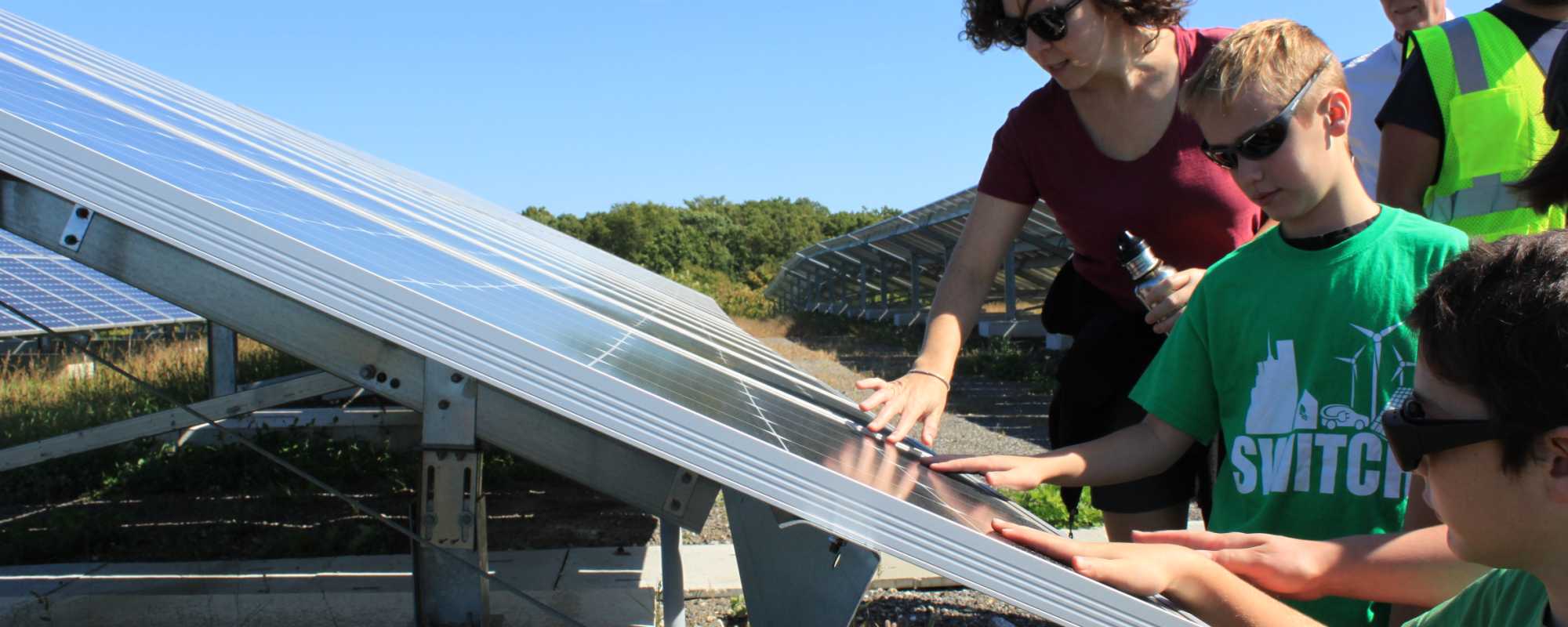 woman and boy up close to solar panels in North Providence, RI